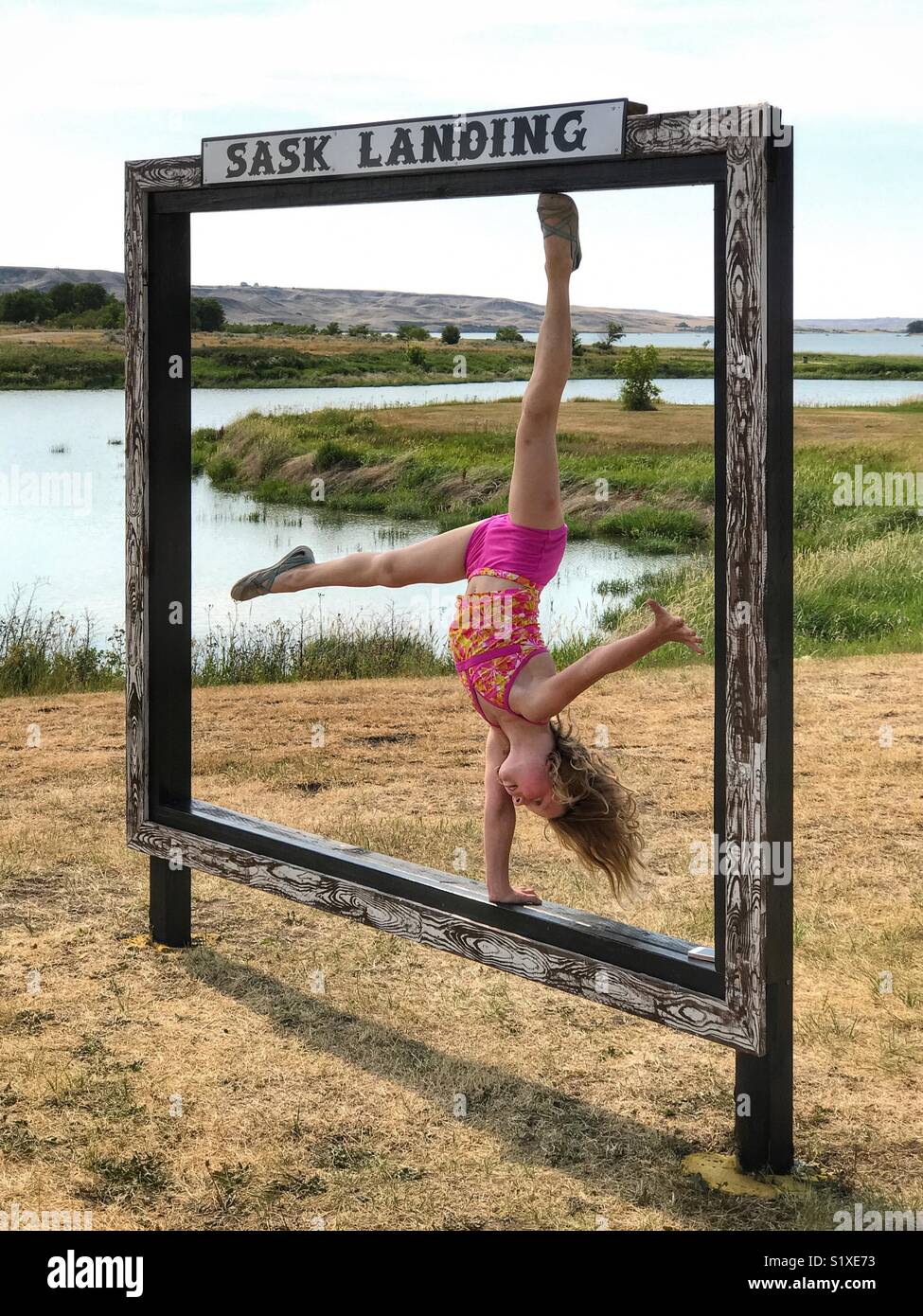 Una ragazza fa un handstand in Saskatchewan Landing, Canada. Foto Stock