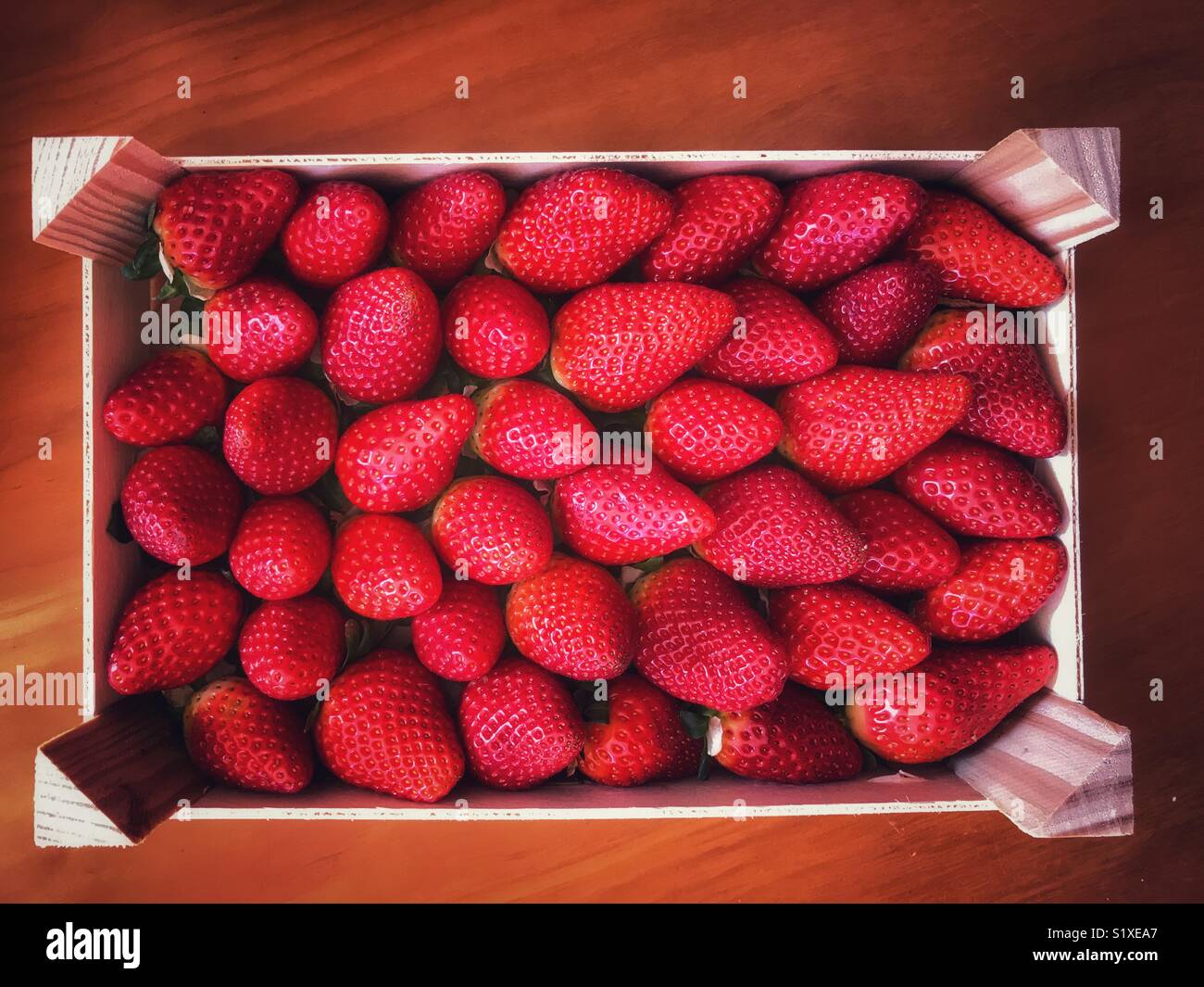 Fragole fresche in un vassoio di legno - Immagine stock catturata con smartphone
