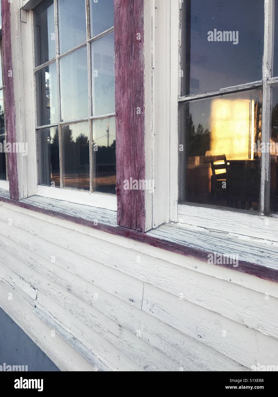 Luce della Sera in una vecchia sala-schoolhouse evidenzia l'insegnante di scrivania e sedia. - Immagine stock catturata con smartphone