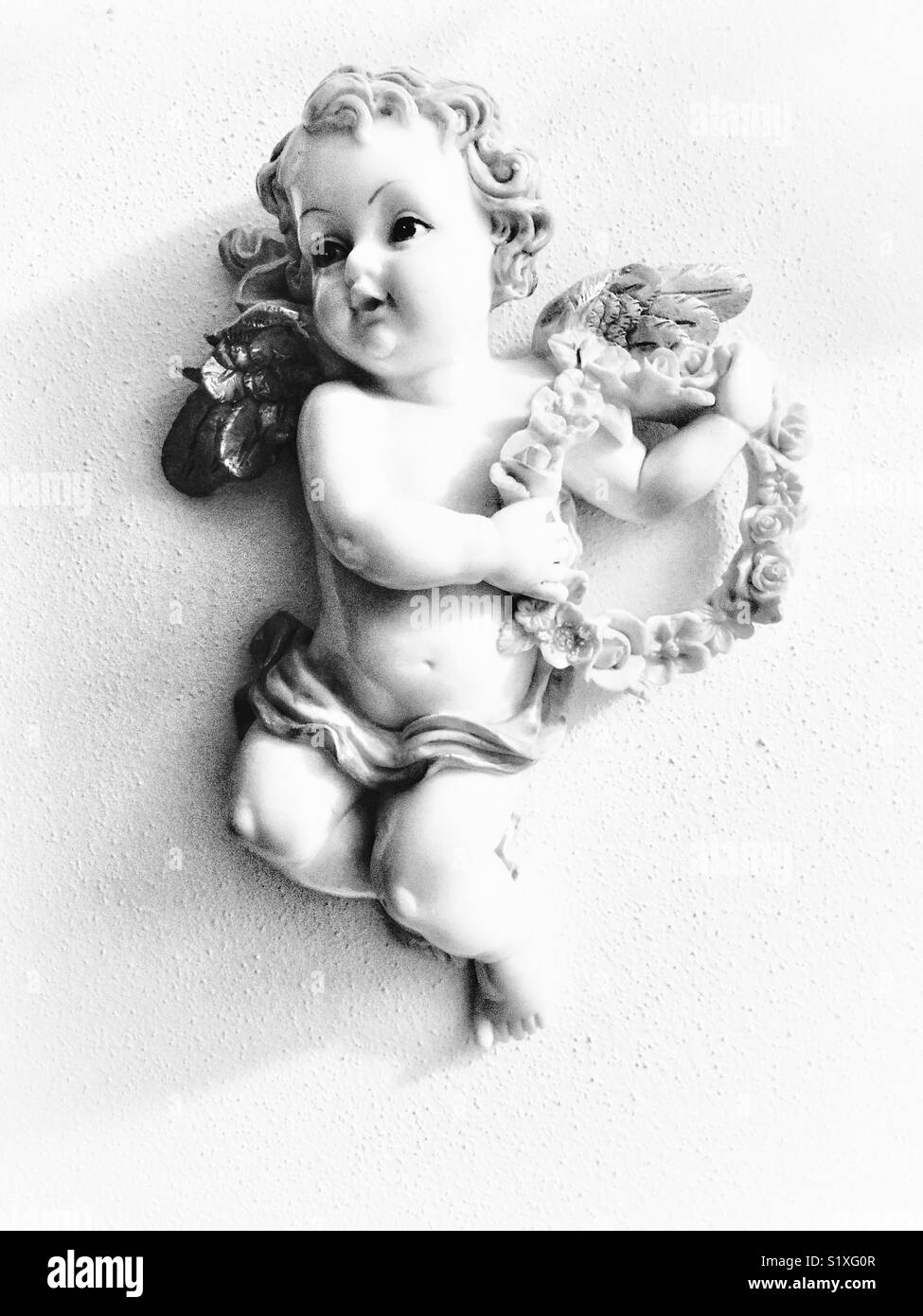 Angelo scultura a parete con ghirlanda di fiori - Immagine stock catturata con smartphone