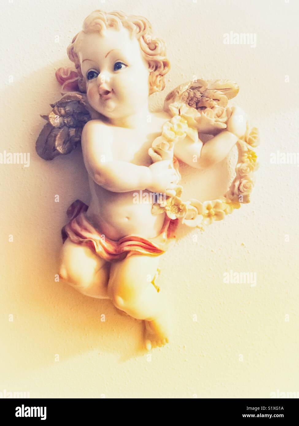 Angelo scultura a parete con ghirlanda di fiori - Immagine stock catturata con smartphone