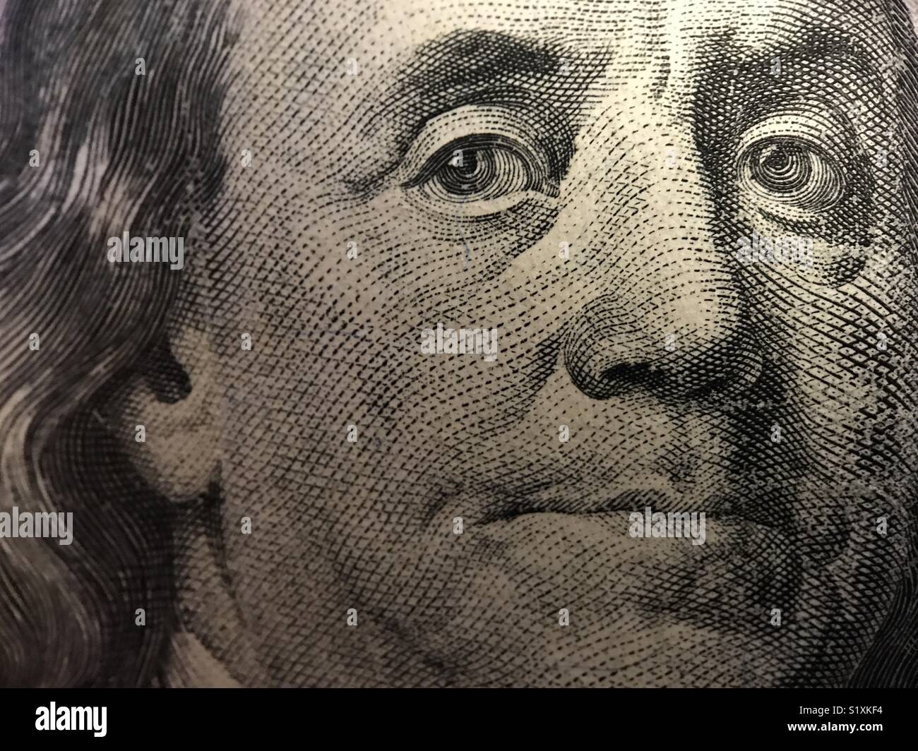 Fino vicino guardare il volto di Benjamin Franklin sulla parte anteriore di un'U.S. $100 bill. - Immagine stock catturata con smartphone