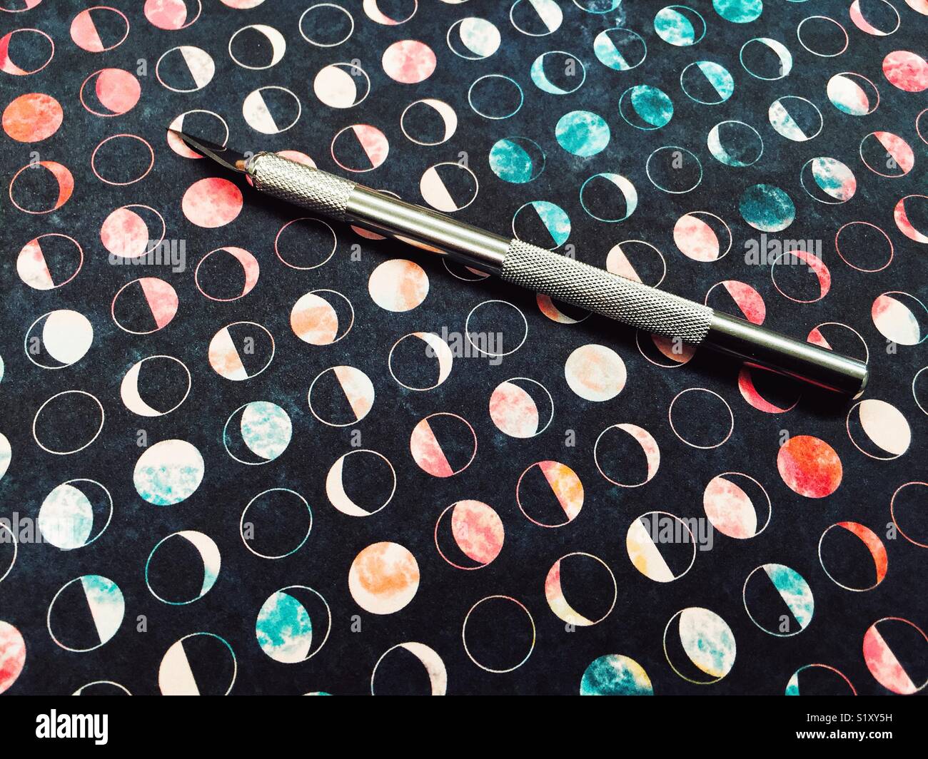 Exacto coltello su scrapbooking carta con fasi lunari sfondo pronto per la creazione di Foto Stock