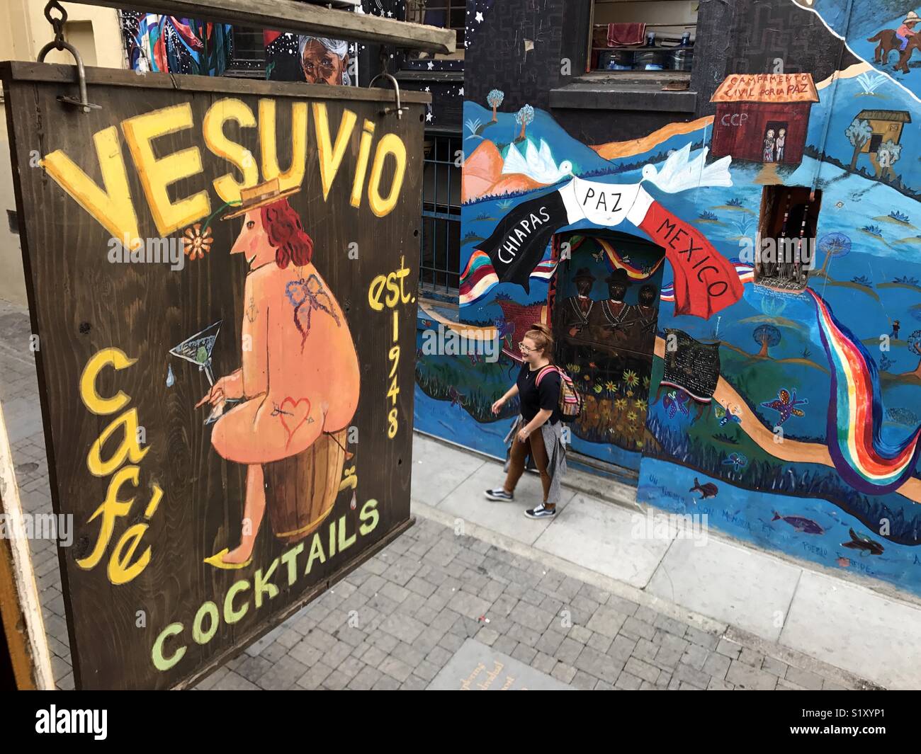 Un segno per il Vesuvio bar e cafe pende su un vicolo con un murale in onore di Chiapas regione sul Messico. Foto Stock