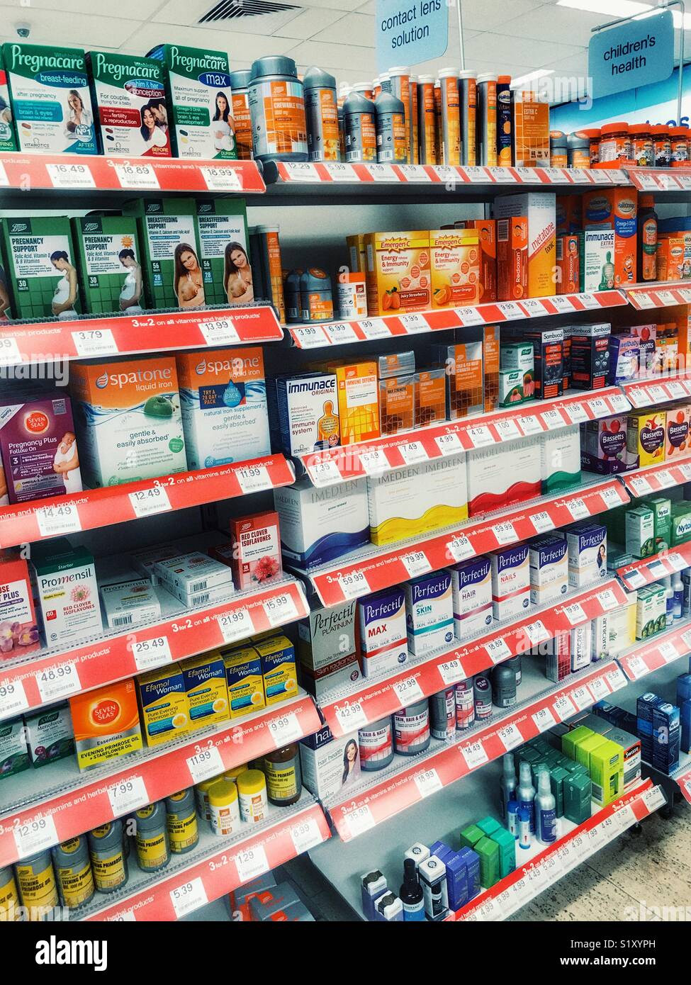 Avvia il farmacista, interno, ben rifornita ripiani con una varietà di farmaci OTC Foto Stock