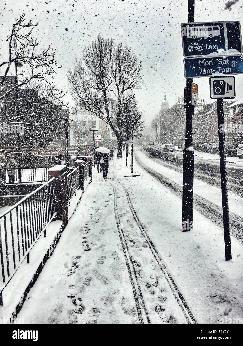 Bestia da est. Condizioni di Blizzard di Londra, febbraio 2018. Scena di strada con una persona a piedi, Orme nella neve, Junction Road, N7 Foto Stock