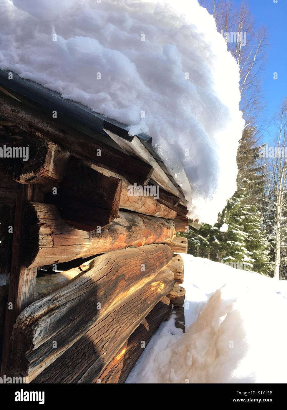 Il vecchio fienile con travi di legno con neve sul tetto Foto Stock