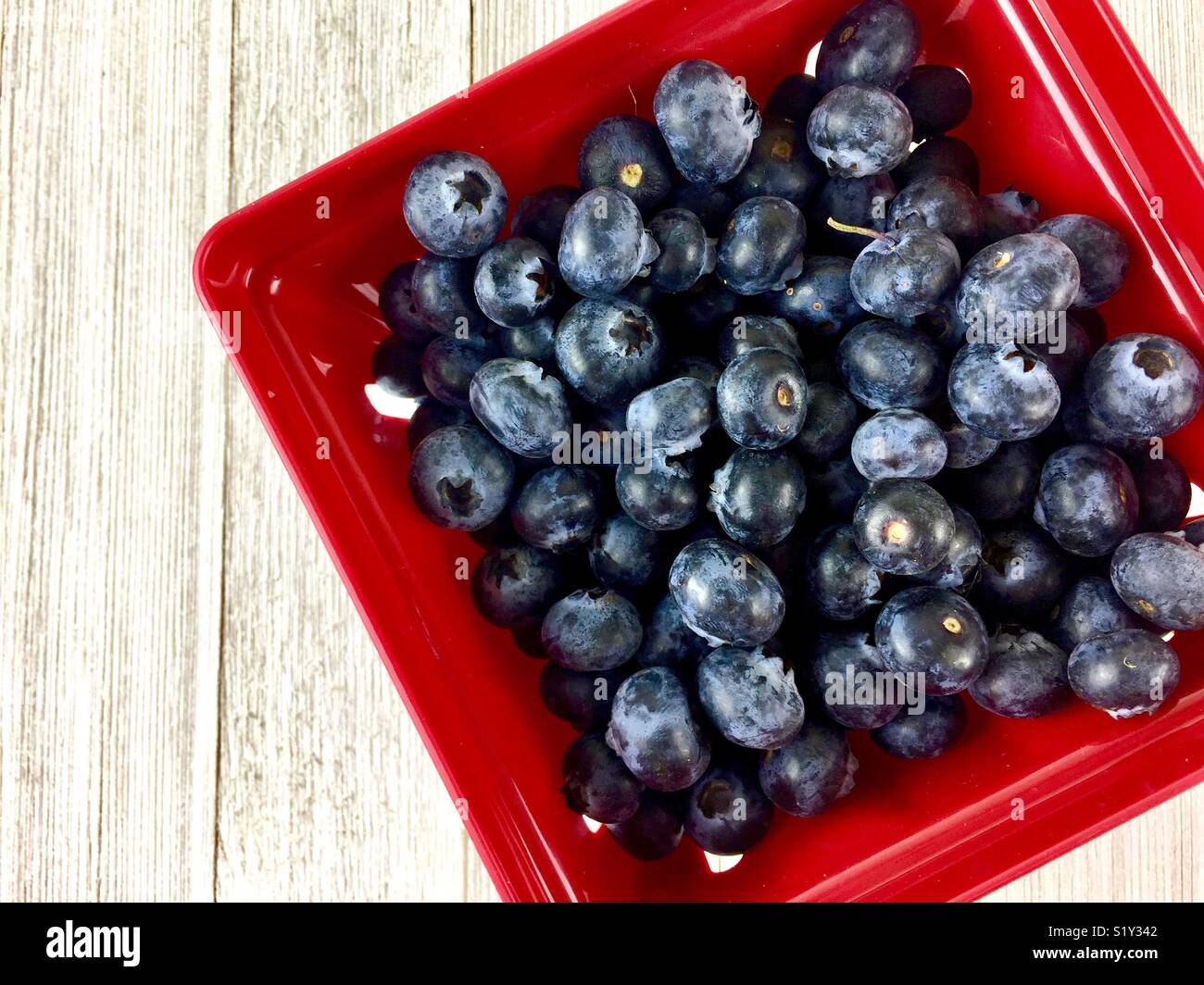 I mirtilli in un contenitore rosso - Immagine stock catturata con smartphone
