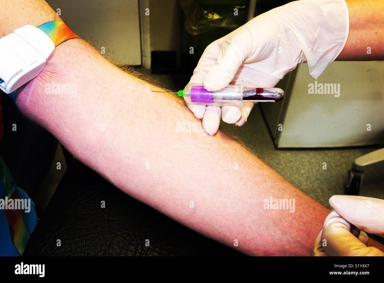 Una pratica infermiere prende un campione di sangue dal braccio di un uomo di mezza età come parte di un NHS health check test. Regno Unito Foto Stock