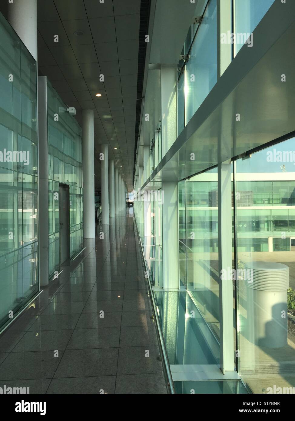 Lungo pareti di vetro corridoio in un aeroporto - Immagine stock catturata con smartphone