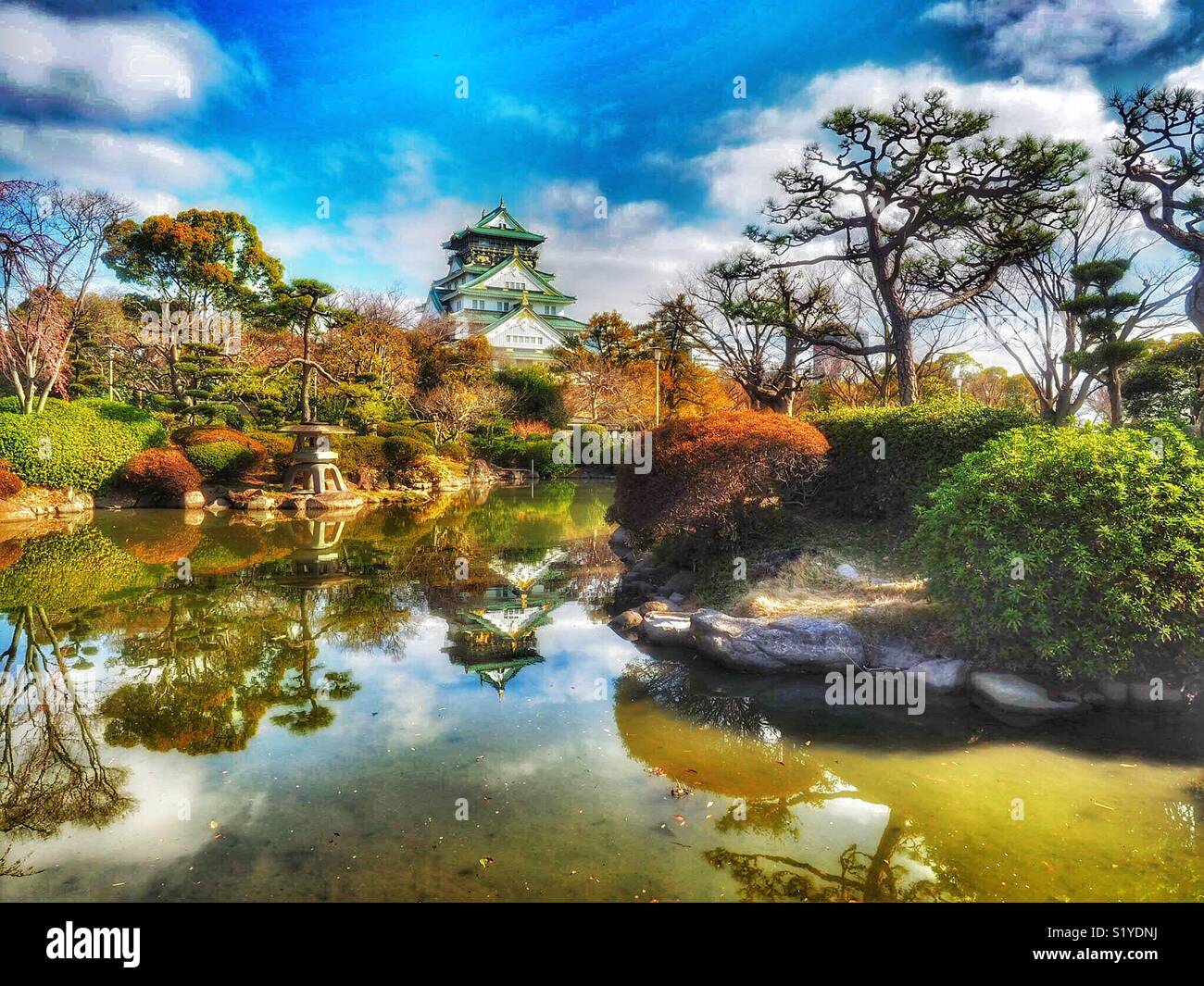 Il Castello di Osaka si riflette in una piscina all'inizio della primavera - Immagine stock catturata con smartphone