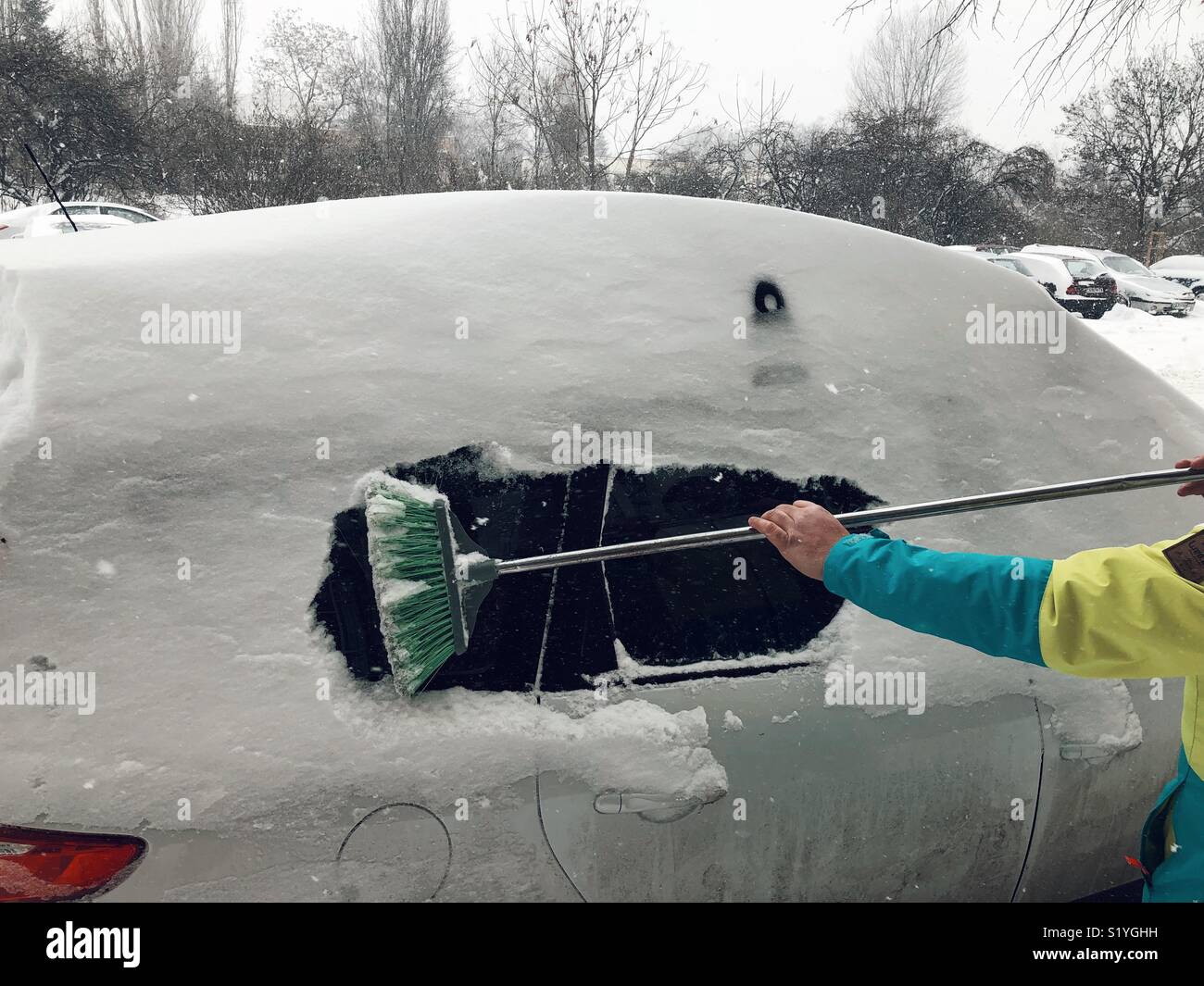 Uomo di neve di pulizia dalla sua auto a Sofia Bulgaria - Immagine stock catturata con smartphone