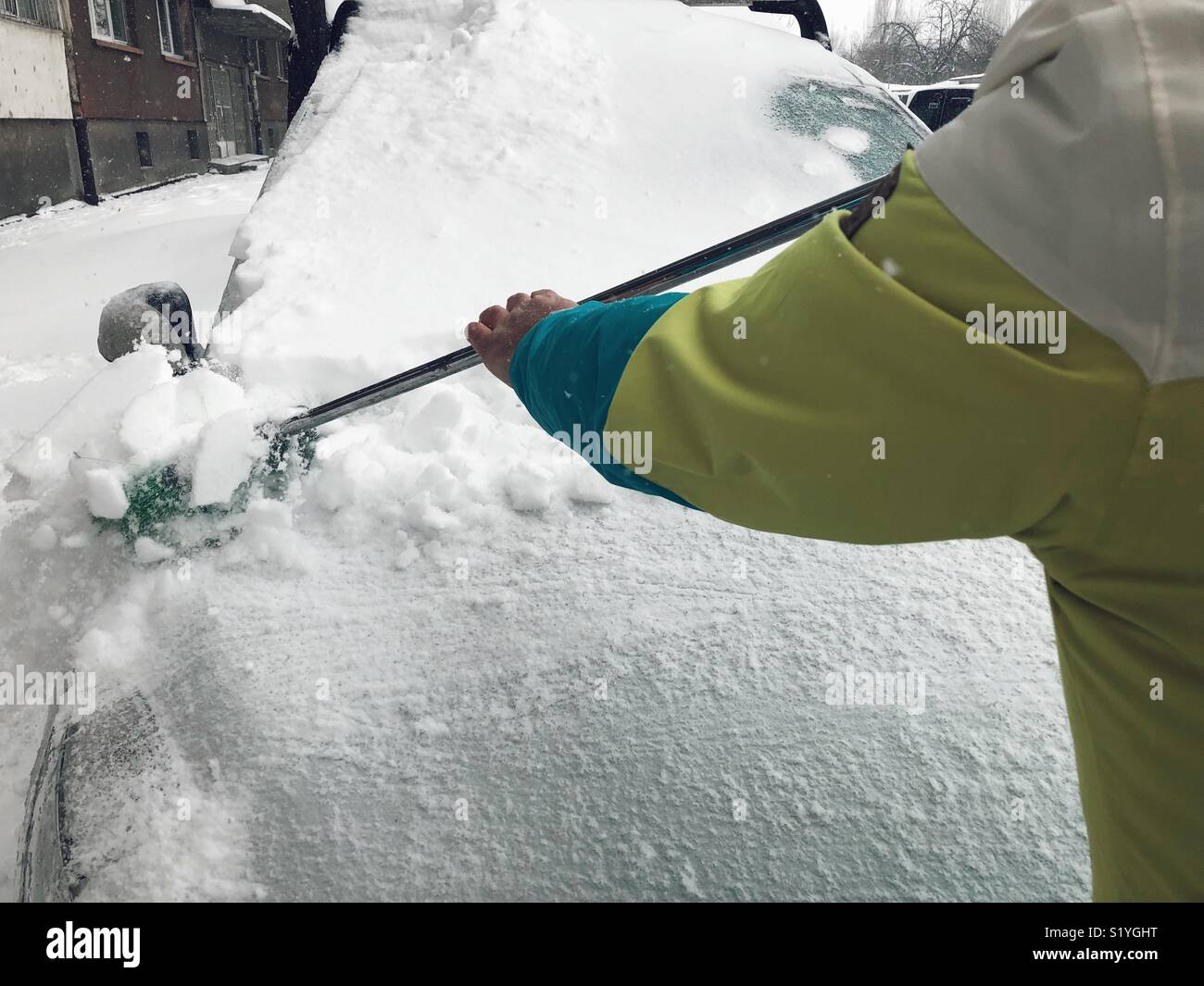 Uomo di neve di pulizia sulla vettura a Sofia Bulgaria - Immagine stock catturata con smartphone