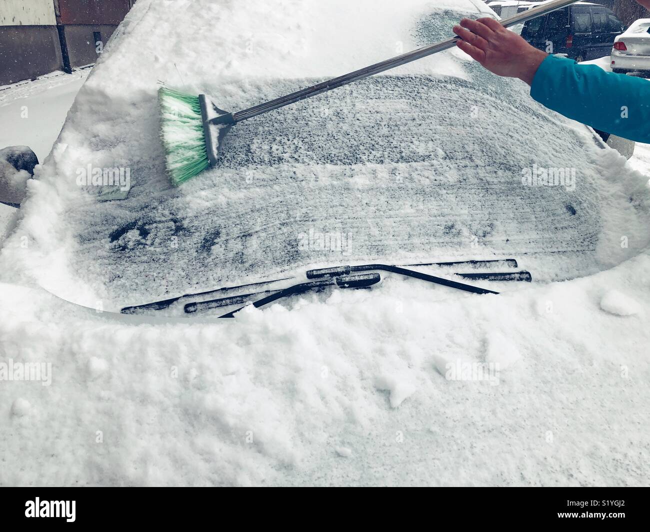 Uomo di neve di pulizia dalla sua auto a Sofia Bulgaria - Immagine stock catturata con smartphone