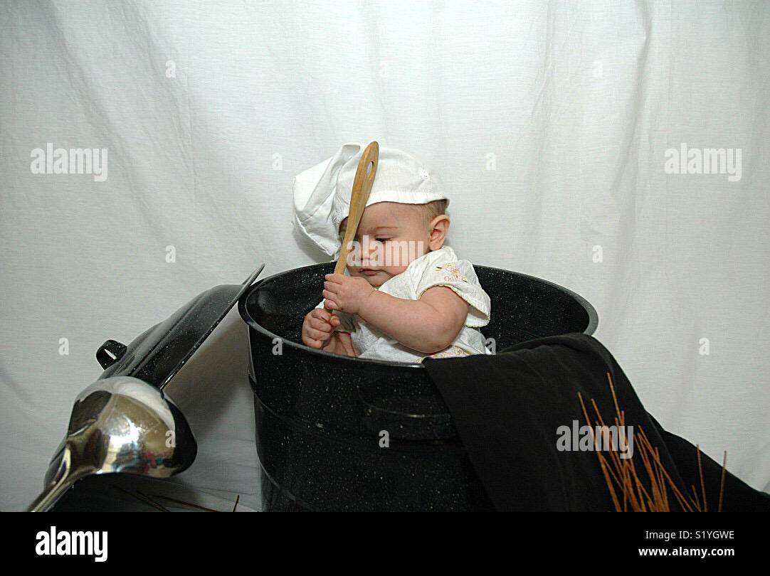 Un bambino gioca con gli attrezzi di cucina. Foto Stock