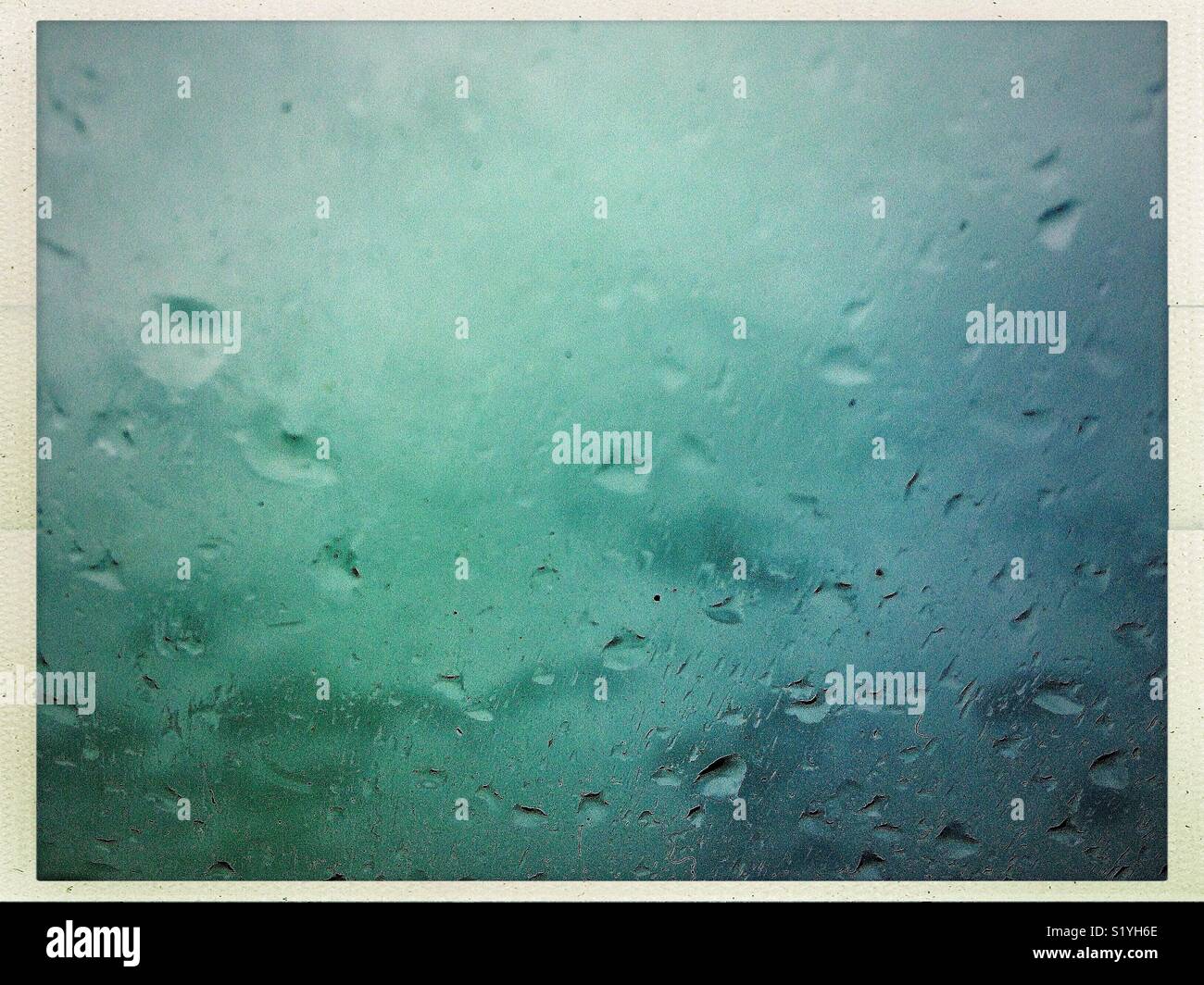 Sfondo blu texture con gocce di pioggia attraverso il parabrezza per il cattivo tempo. - Immagine stock catturata con smartphone