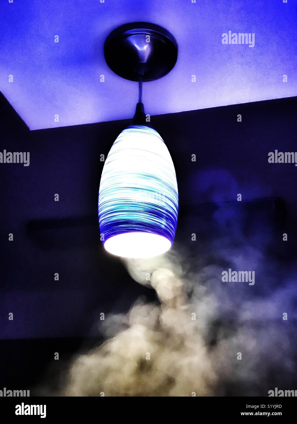 Appendere la luce blu su smoky bar Foto Stock