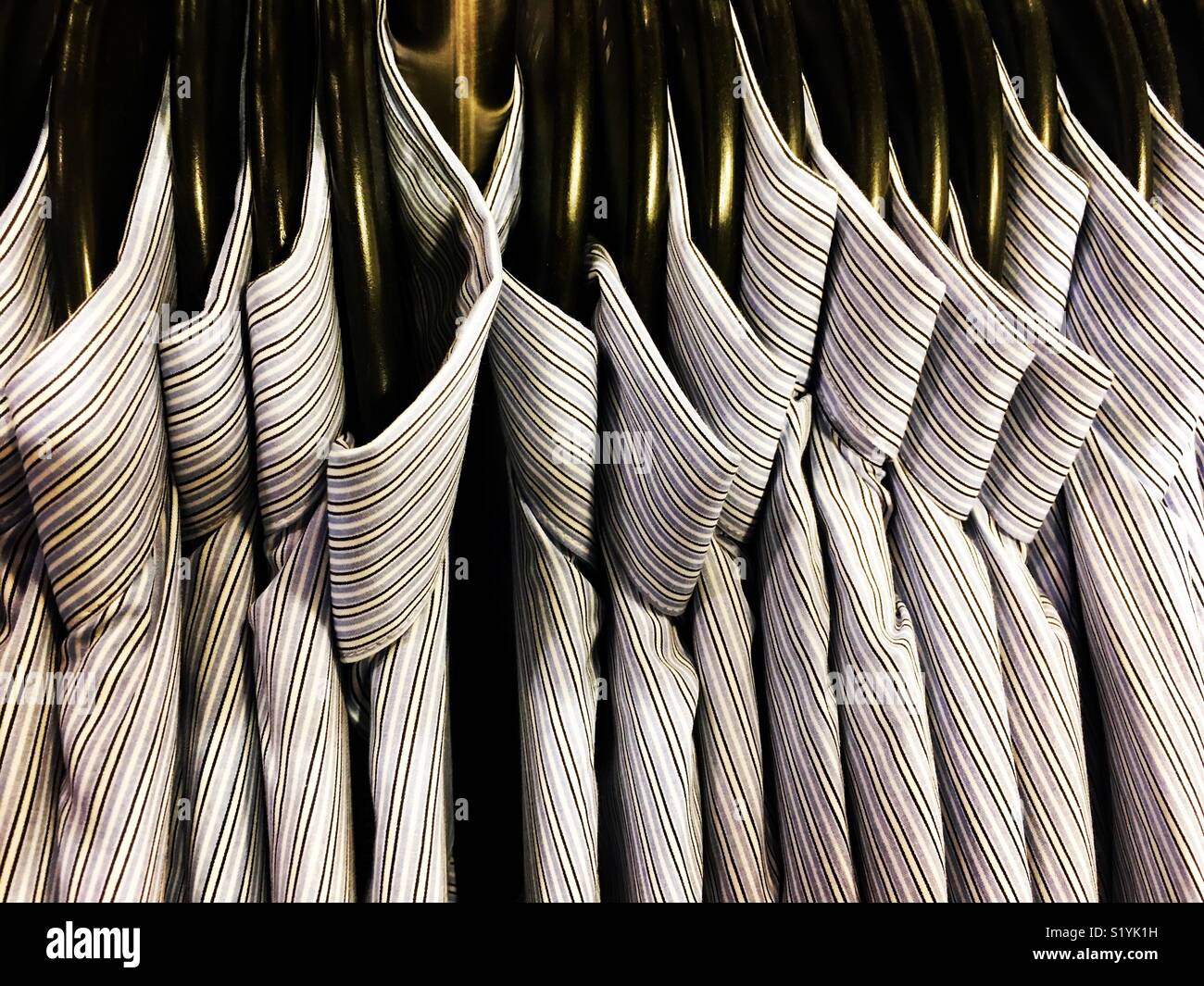 Rack di camicie di cotone su appendiabiti. Foto Stock