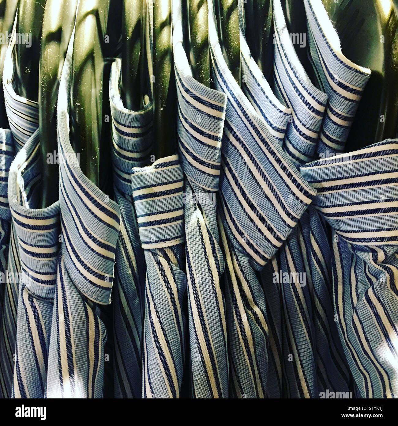 Rack di camicie di cotone su appendiabiti. Foto Stock