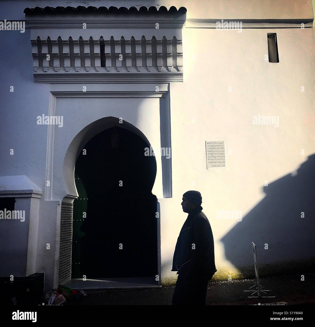 Un uomo cammina davanti ad una moschea a Tangeri, Marocco, Africa - Immagine stock catturata con smartphone