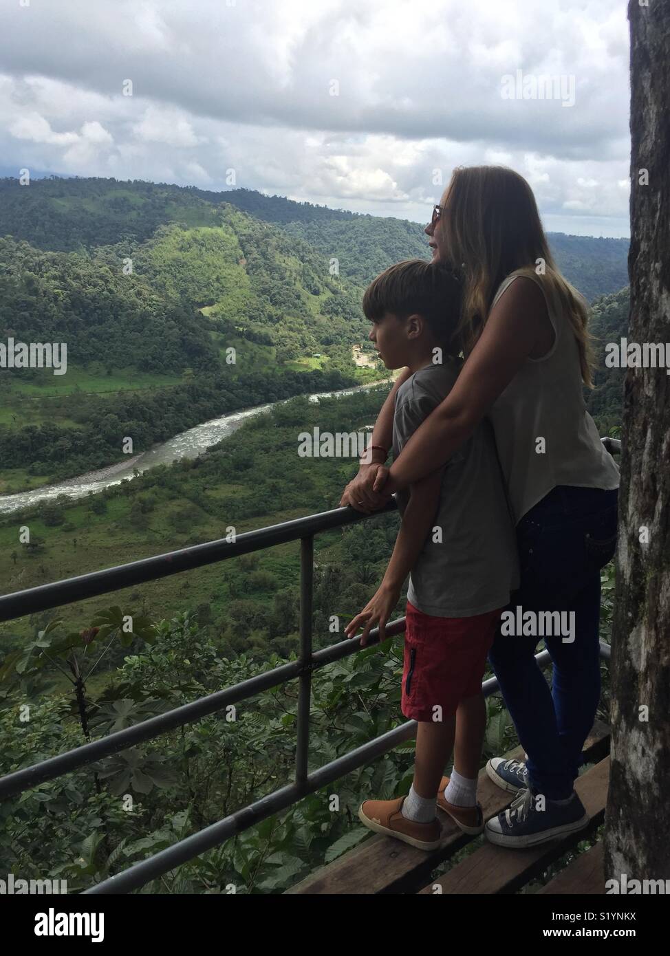 Una madre y su hijo contemplando la naturaleza, observan el río y la Montaña del bosque nuboso en los Bancos en Ecuador Foto Stock