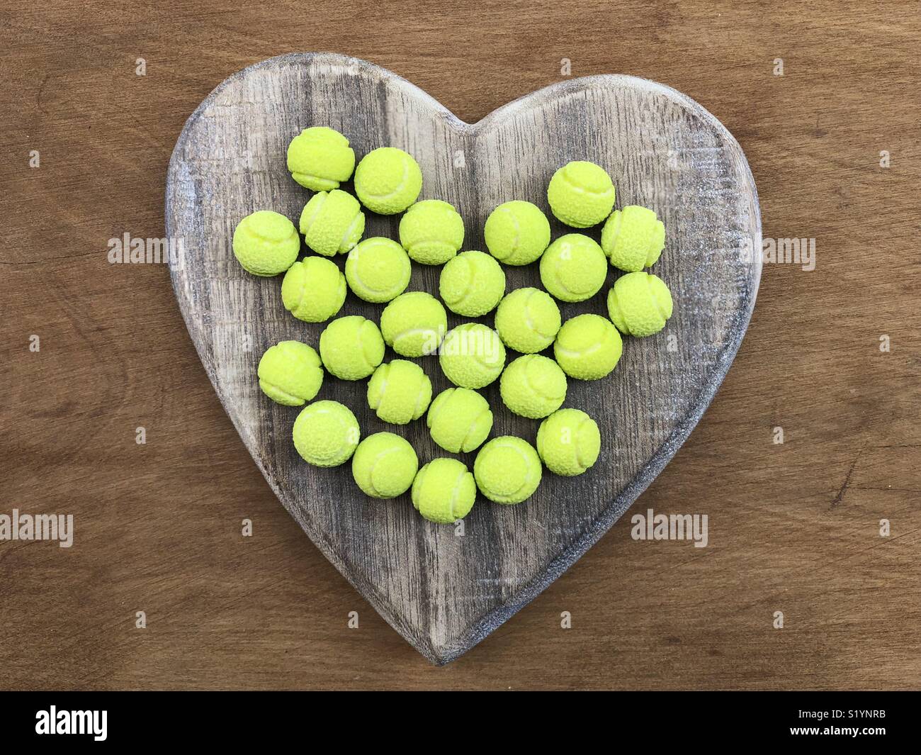 Amore mio dolce palle da tennis bon bons su un cuore di legno Foto Stock