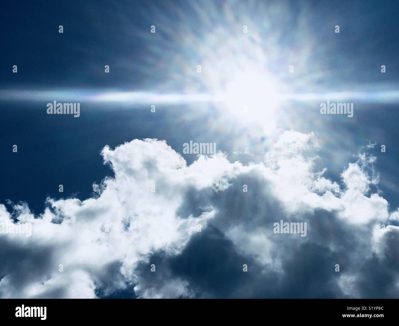Sole che splende blu del cielo Foto Stock