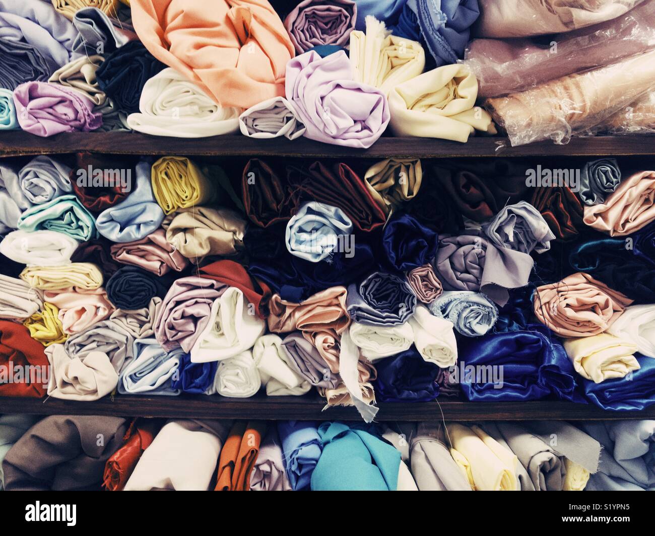 Colorato di rotoli di tessuto in una Bangkok sarti da donna shop. Foto Stock
