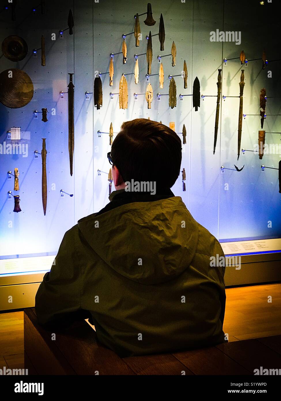 Un ragazzo contempla teste lancia nel Museo di Londra. Foto Stock