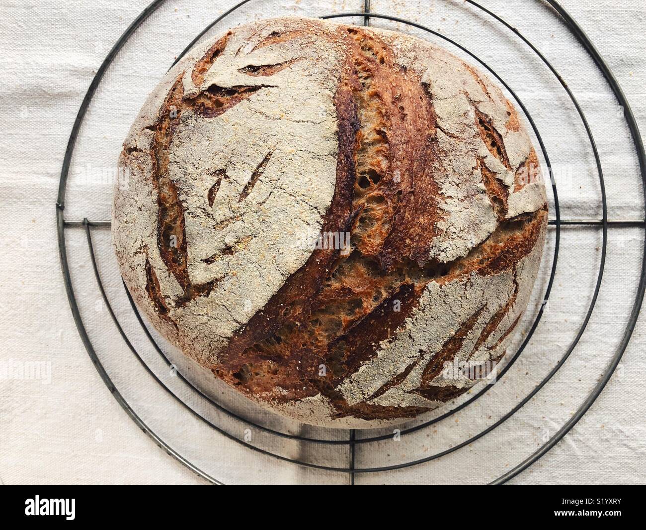 Pane casereccio pane di pasta acida raffreddamento sulla griglia da forno - Immagine stock catturata con smartphone