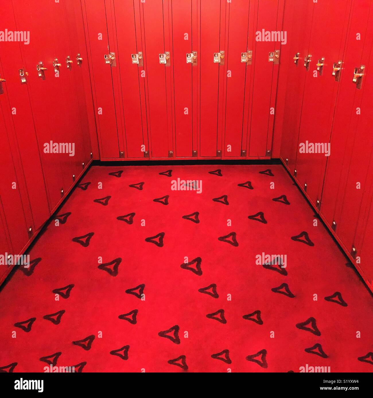 Una luminosa sala rossa di armadietti con ricchi, moquette rossa Foto Stock