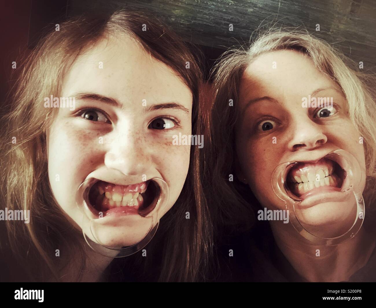 La figlia e la madre selfie indossando i separatori di bocca Foto Stock