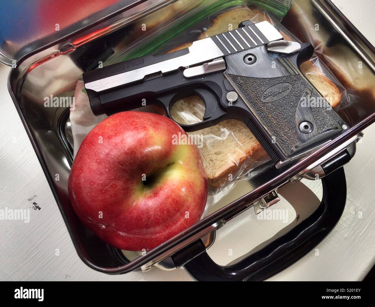 Piccola pistola nascosta in una scuola bambini scatola di pranzo, Stati Uniti - Immagine stock catturata con smartphone