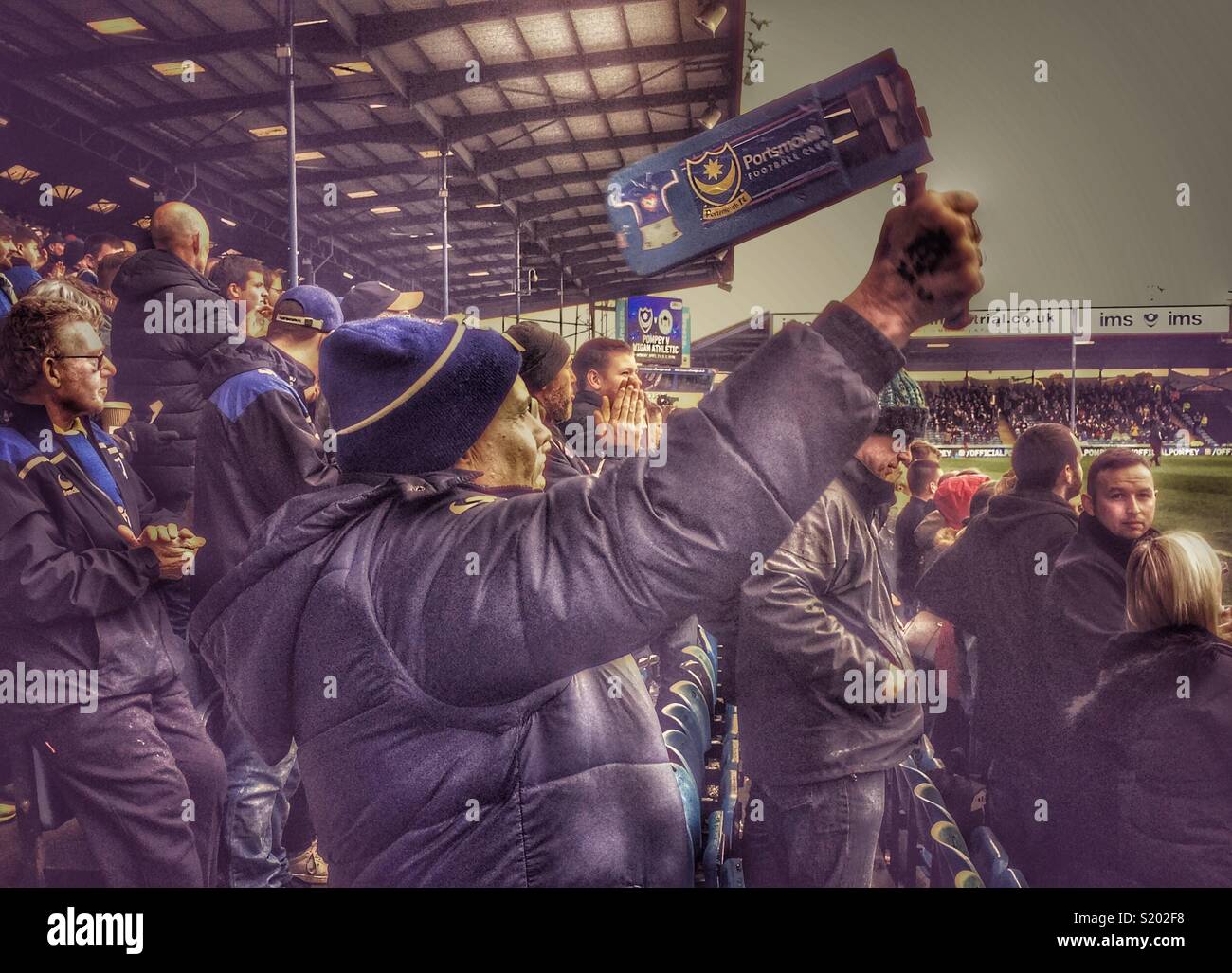 Pompeo, Portsmouth sostenitore utilizzando un tradizionale battito di calcio durante una partita, Fratton Park di Portsmouth, Hampshire, Inghilterra, Regno Unito - Immagine stock catturata con smartphone