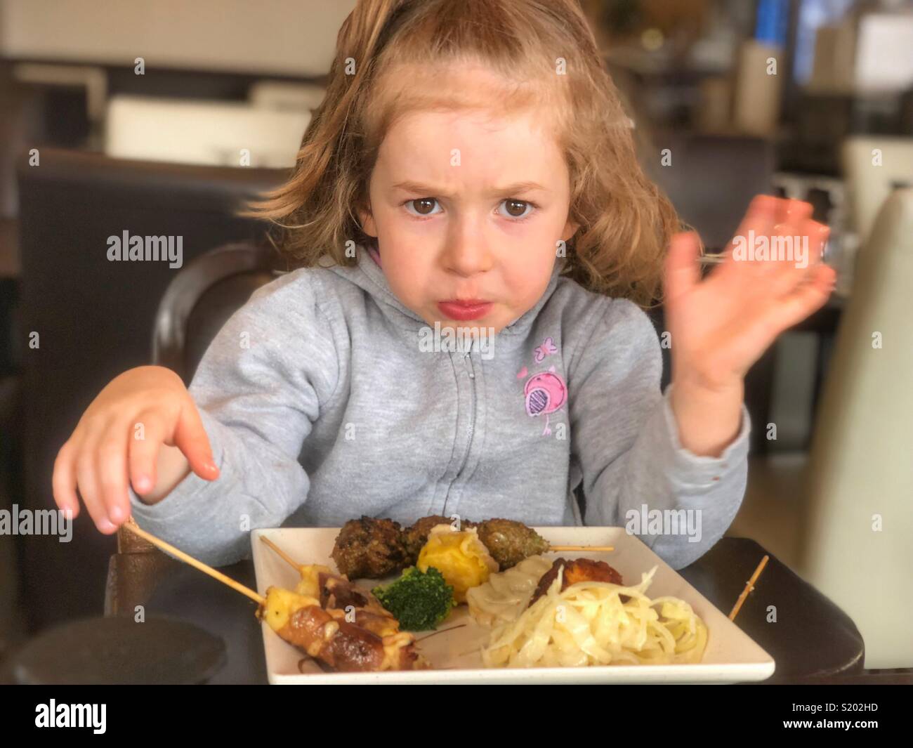 Insoddisfatto ragazza di mangiare nel ristorante Parigi Francia Foto Stock