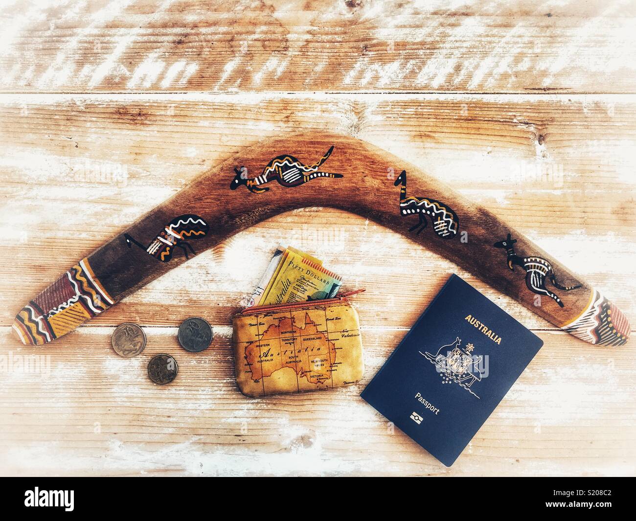 Flat-lay fotografia. Australian Travel, passaporti, monete, portamonete, banconote e boomerang su un tavolo rustico con spazio di copia Foto Stock