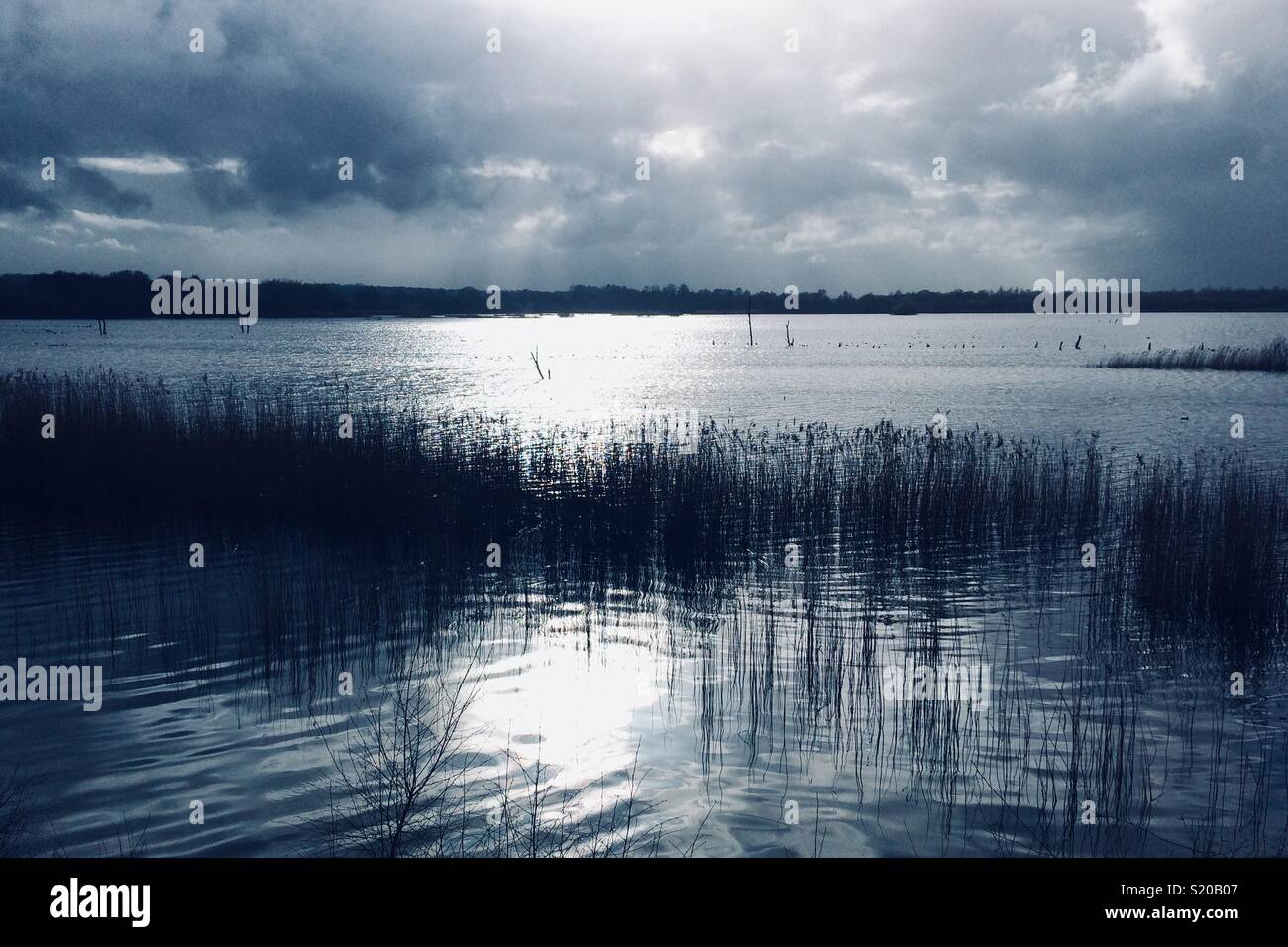 Toni blu del lago con riflessioni e luminose Foto Stock