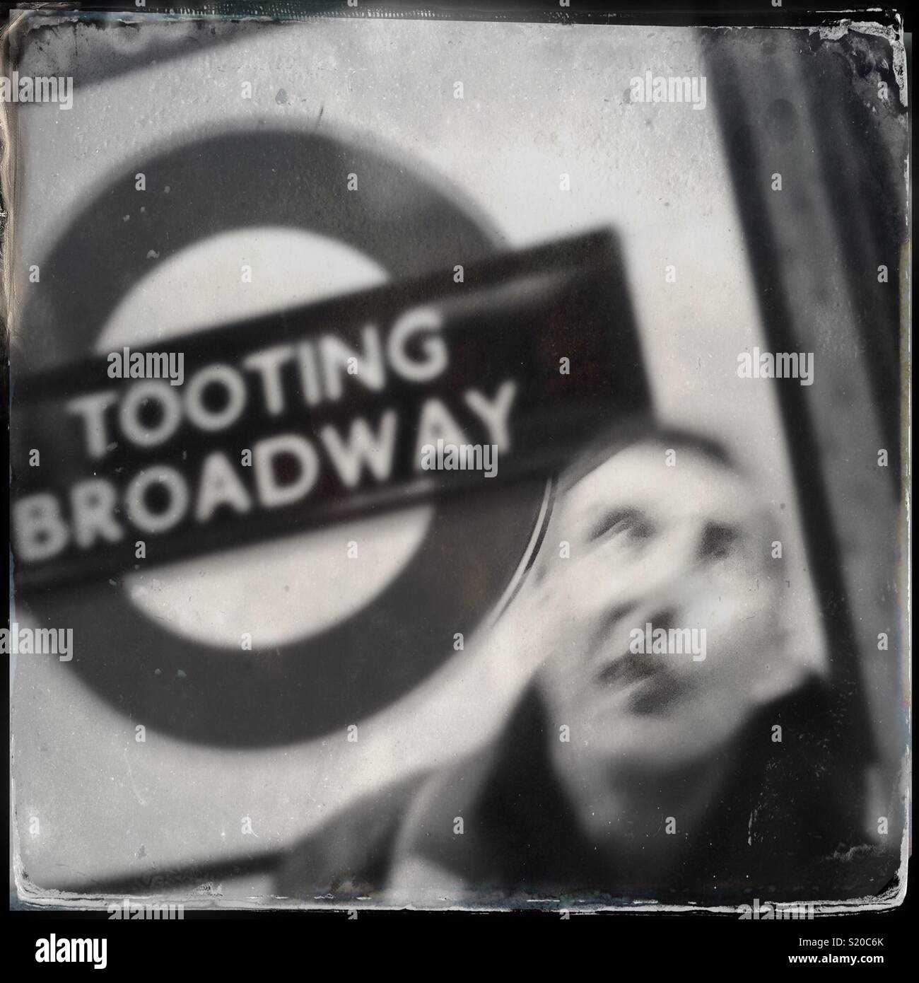 Uomo di attesa per tubo a Tooting Broadway Station di Londra, Inghilterra Foto Stock