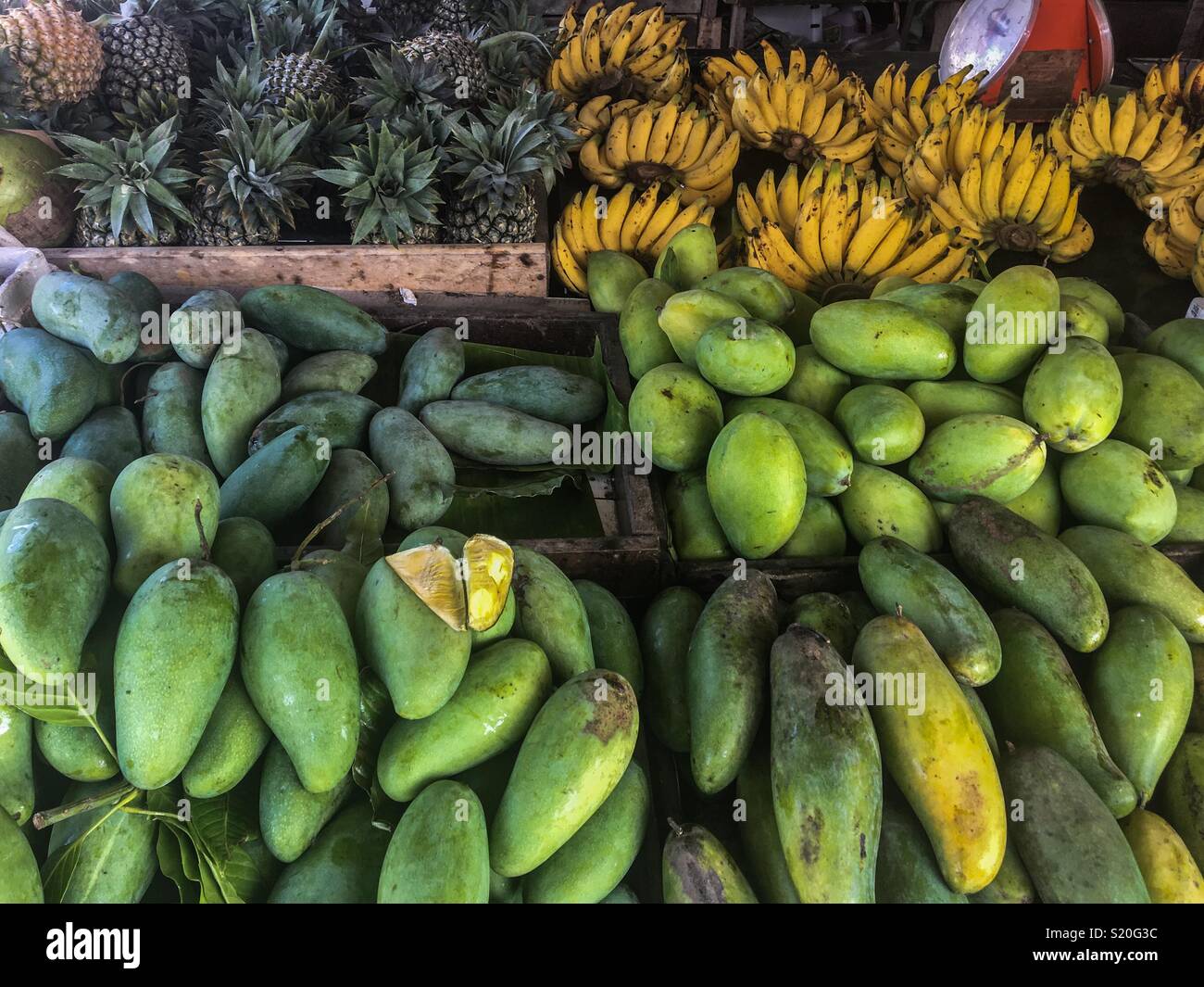 Un mercato di frutta stallo nella città di Phuket in Thailandia con un fresco e Mango, ananas e banane Foto Stock