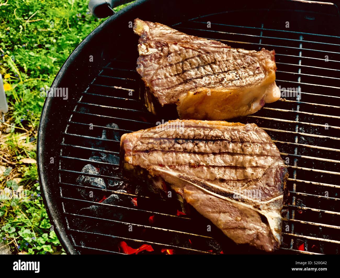 T-Bone Steak su una fiamma aperta Grill - Immagine stock catturata con smartphone