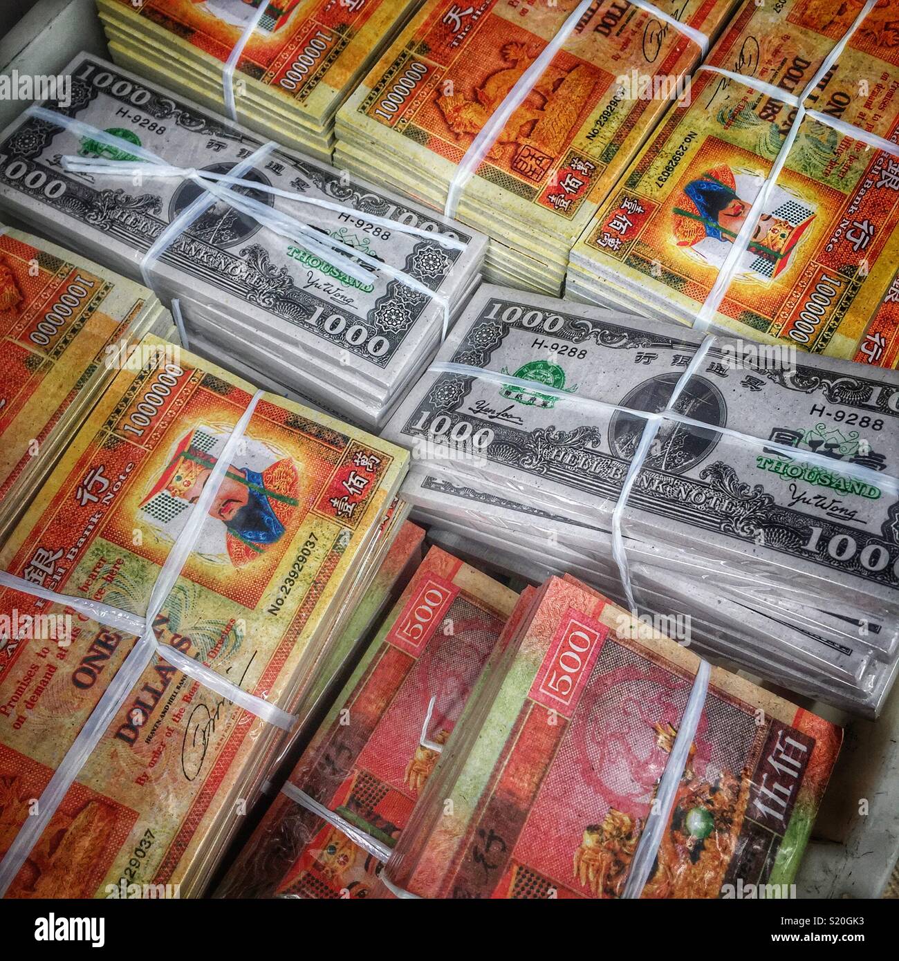 Joss carta, o 'ghost denaro", tra cui "Hell Banconote" in stile US greenback, in vendita in un negozio del villaggio in Sha Tin, Nuovi Territori di Hong Kong - Immagine stock catturata con smartphone