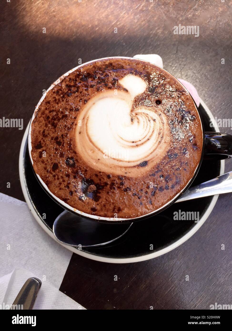 Foto di una tazza di caffè con un design apple in schiuma Foto Stock