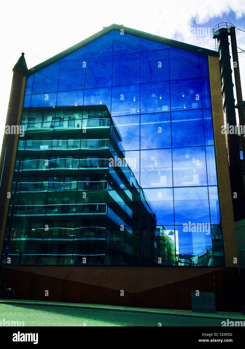 Edificio di appartamenti e riflessa nel vetro enorme edificio con la facciata a Stoccolma Foto Stock