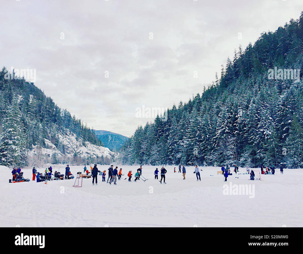 Pond Hockey sul lago ghiacciato in montagna Foto Stock