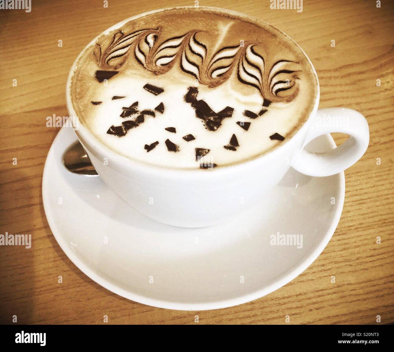 Arte in una tazza di caffè - un cappuccino con un design intelligente sulla parte superiore. Foto Stock
