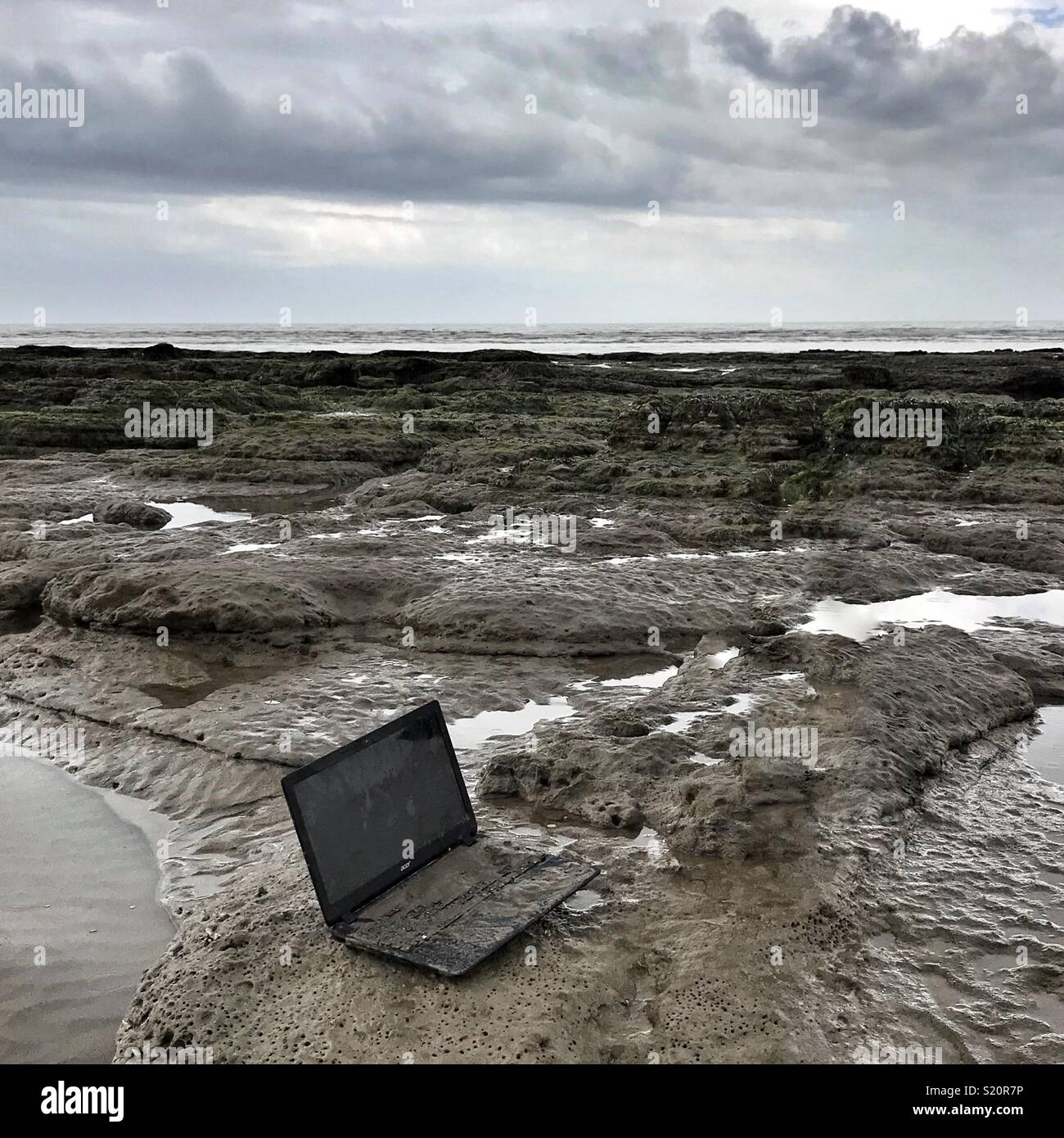 Laptop scartato sulla spiaggia - Immagine stock catturata con smartphone