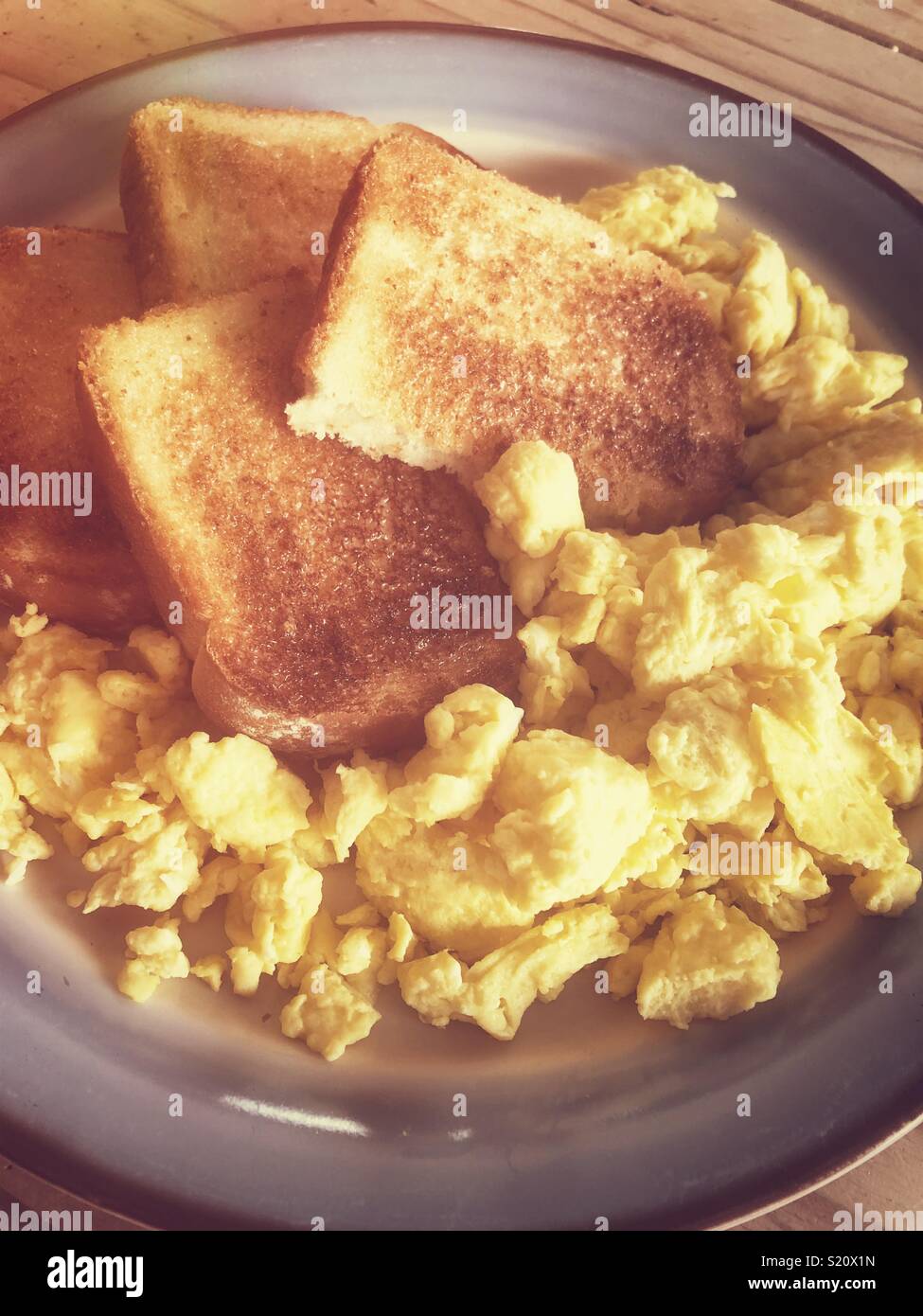 Uova strapazzate e toast sulla piastra nella calda luce del mattino - Immagine stock catturata con smartphone