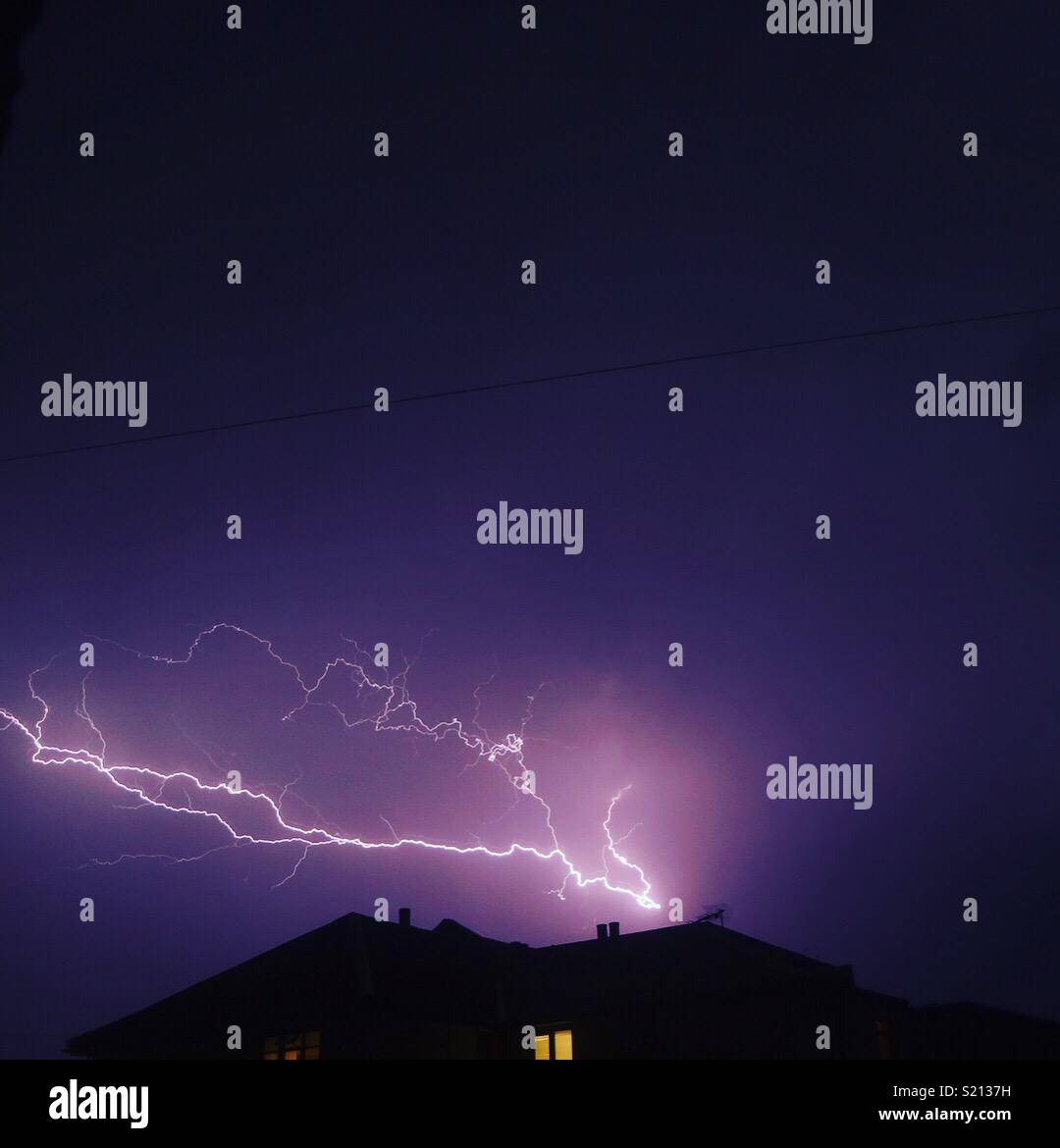 Un fulmine nel cielo sopra una casa Foto Stock