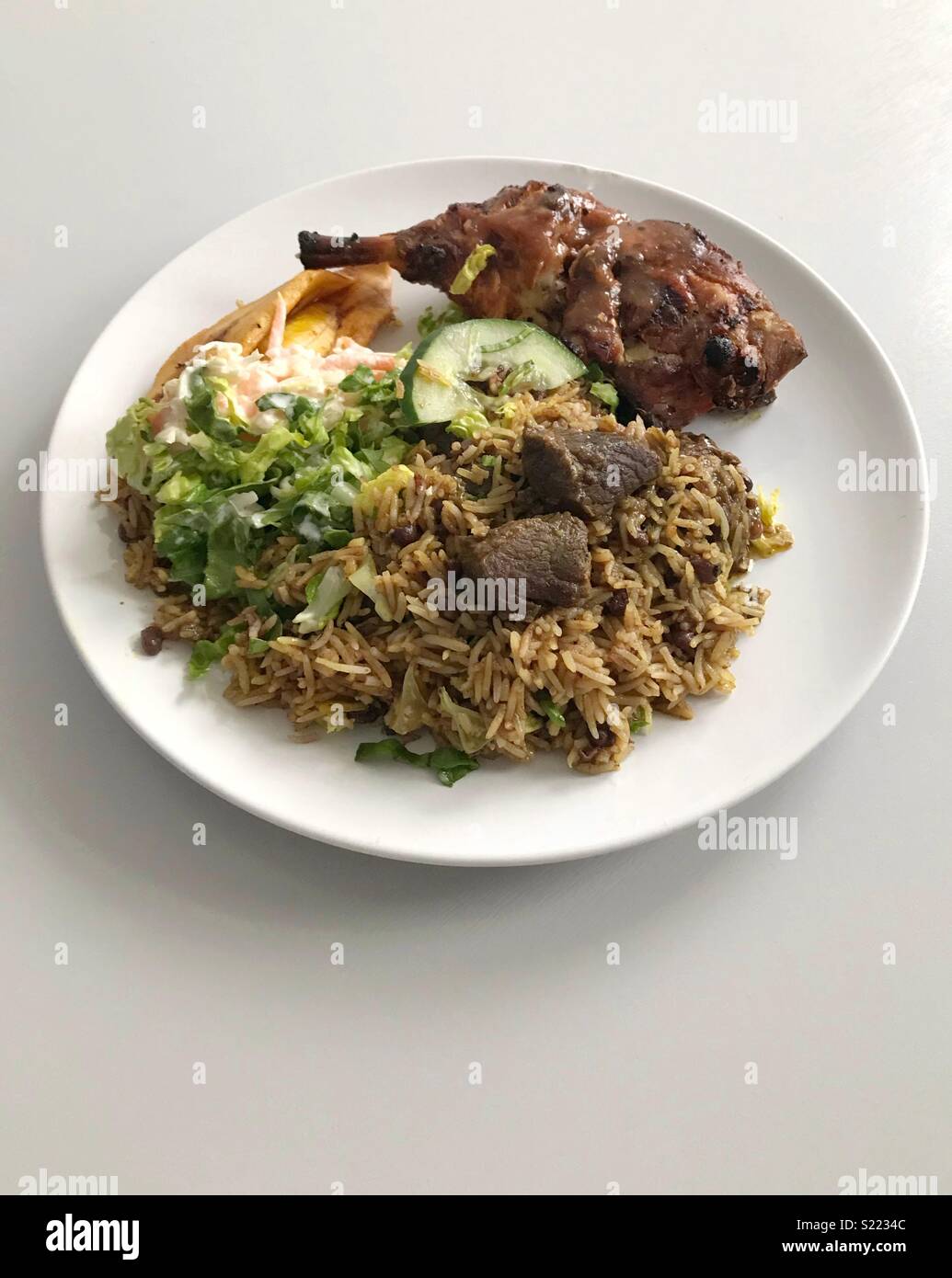 Una piastra di caprini/curry di montone e pollo jerk Foto Stock