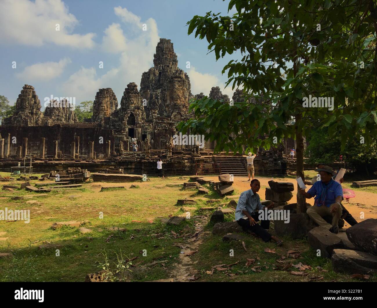 Persone in appoggio sotto agli alberi in ombra in una giornata calda a Angkor Wat in Cambogia - Immagine stock catturata con smartphone